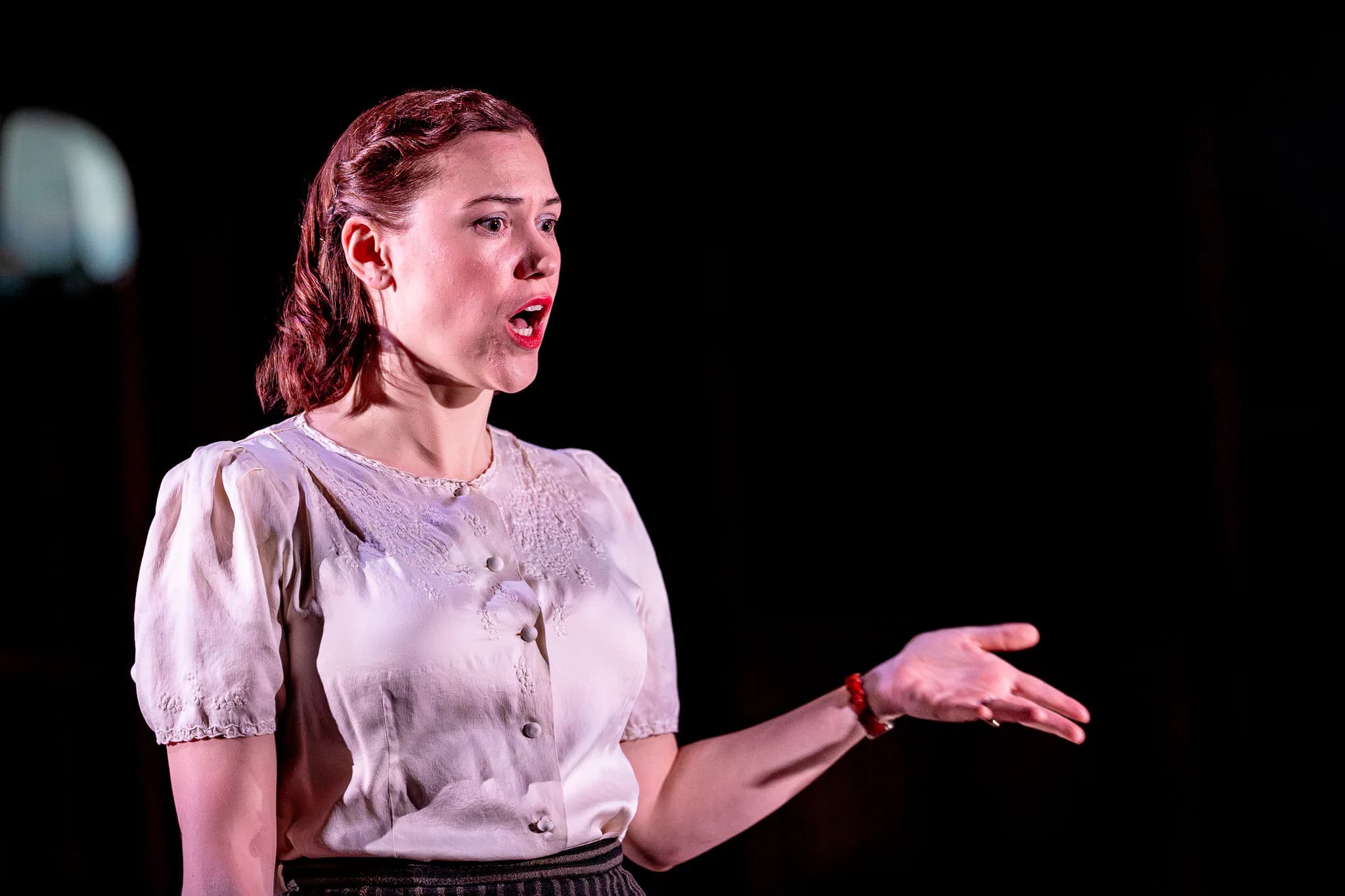 Solo performer delivers an urgent monologue, arm outstretched, under warm spotlight in 3 Winters at ArtsEd, 2024.