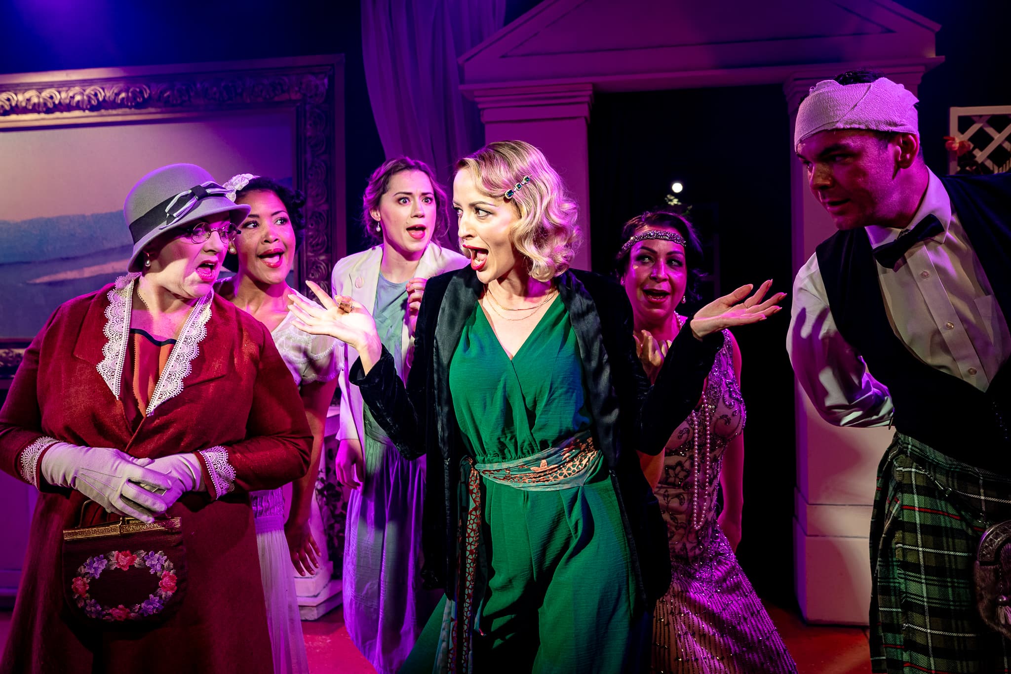 The company of Extraordinary Women gathered in a colourful ensemble scene