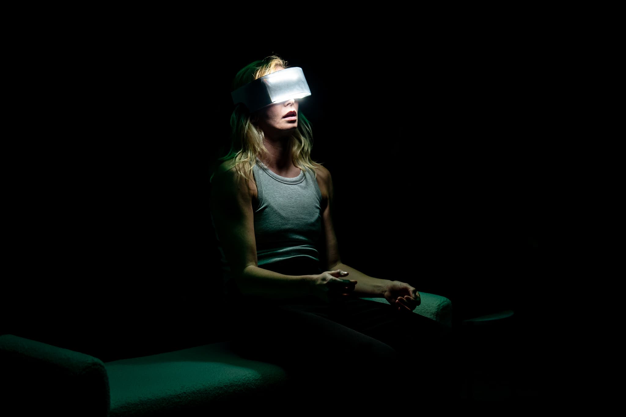 A seated performer wearing a glowing visor