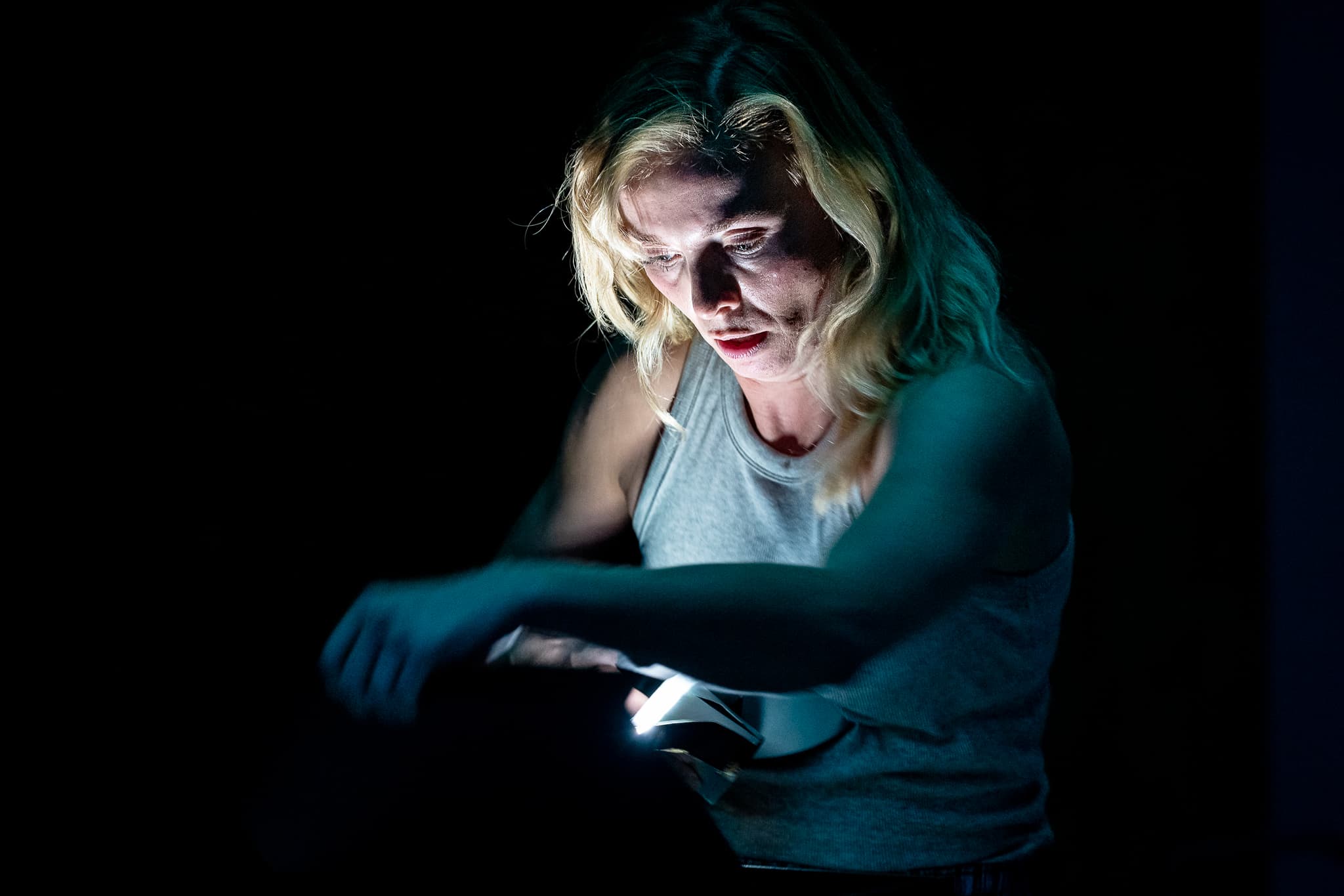 A close portrait illuminated by a digital screen