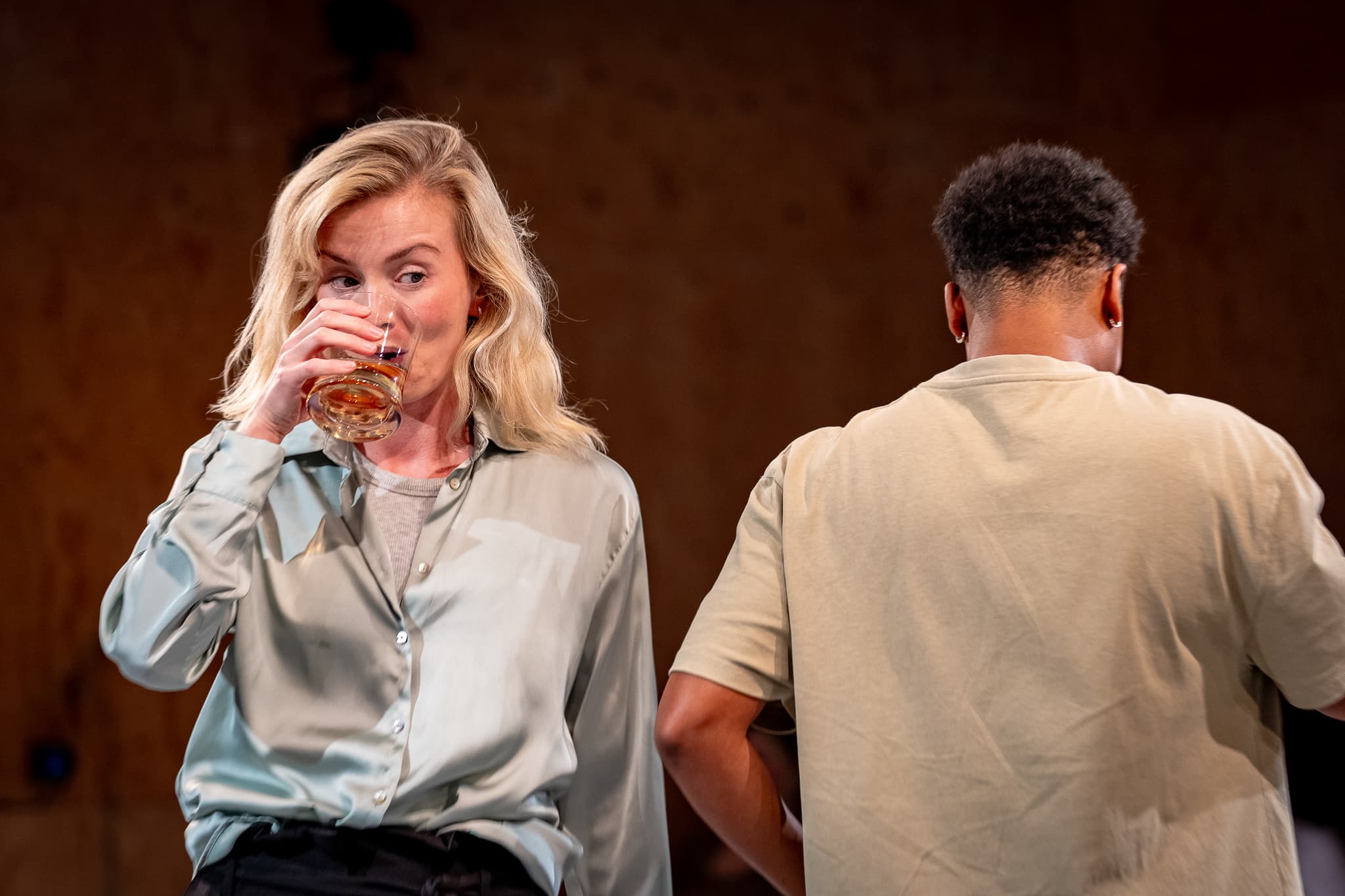 A performer drinking during a scene from Girl In The Machine