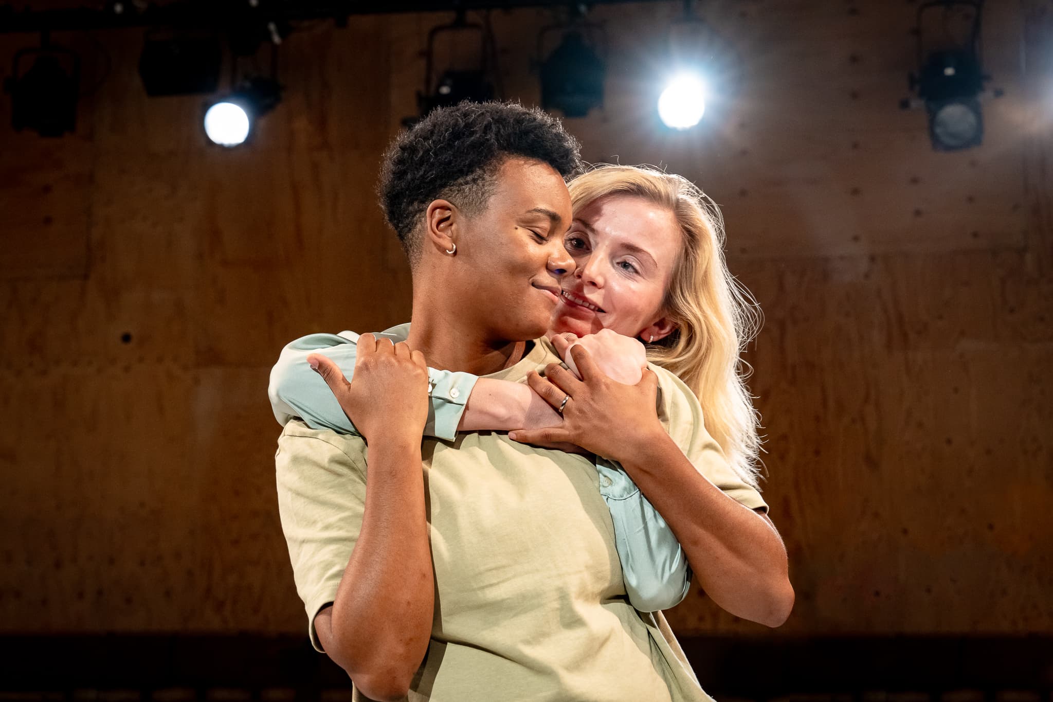 Two performers embracing on stage