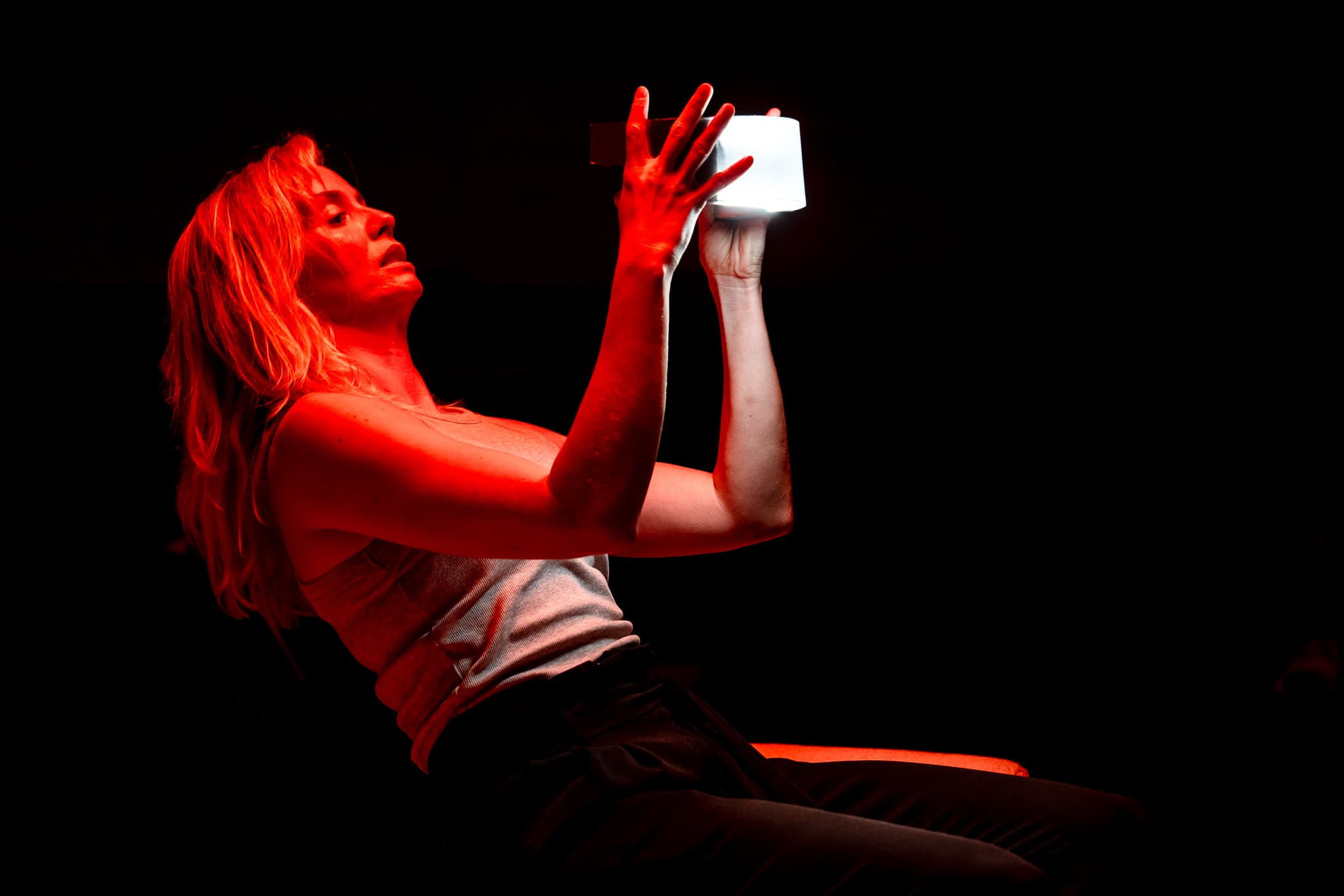 A performer illuminated by intense red light