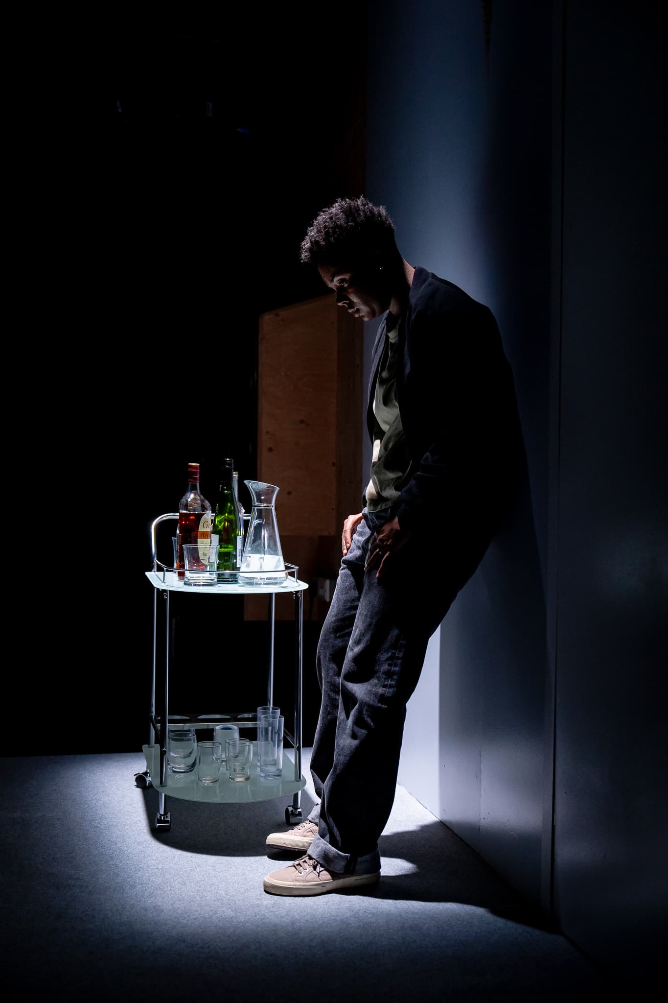 A solitary performer standing in a narrow pool of light