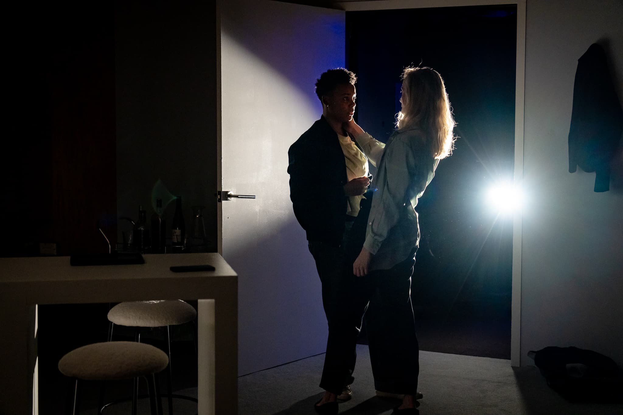 Two performers silhouetted by stage lighting