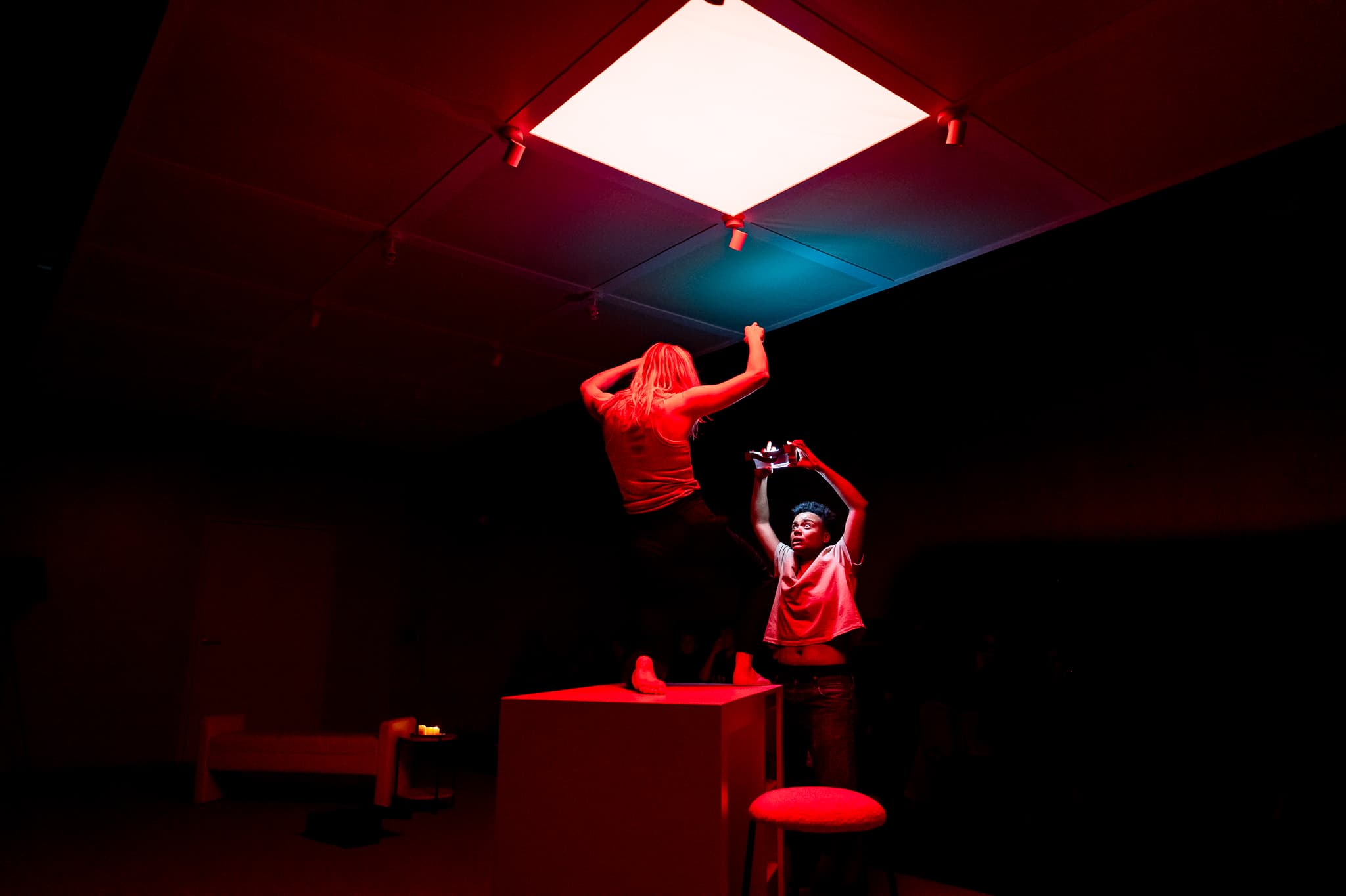 Performers beneath a dramatic red illuminated ceiling