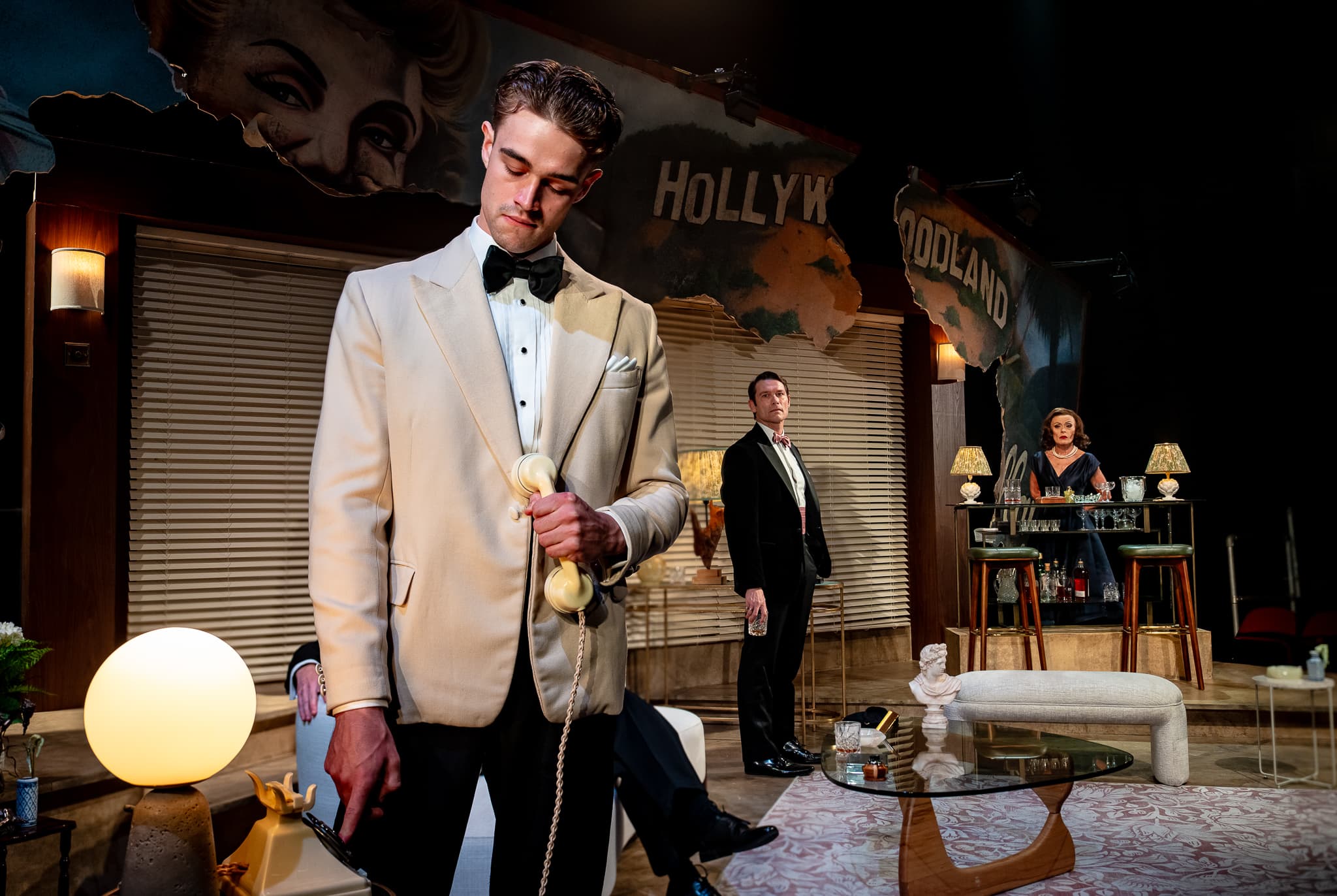 A performer in formal costume holding a drink in The Code